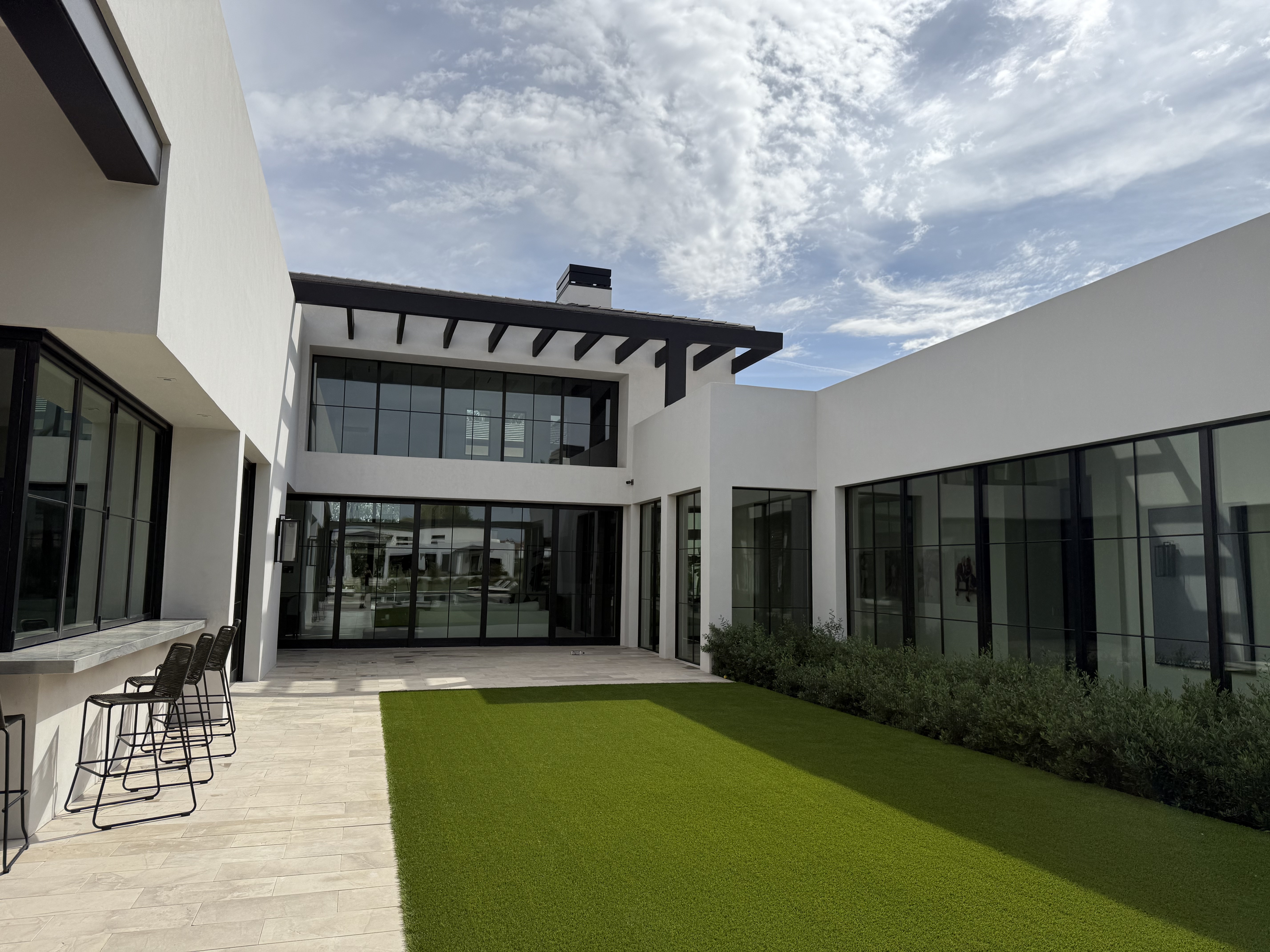 Modern courtyard with artificial turf and travertine pavers