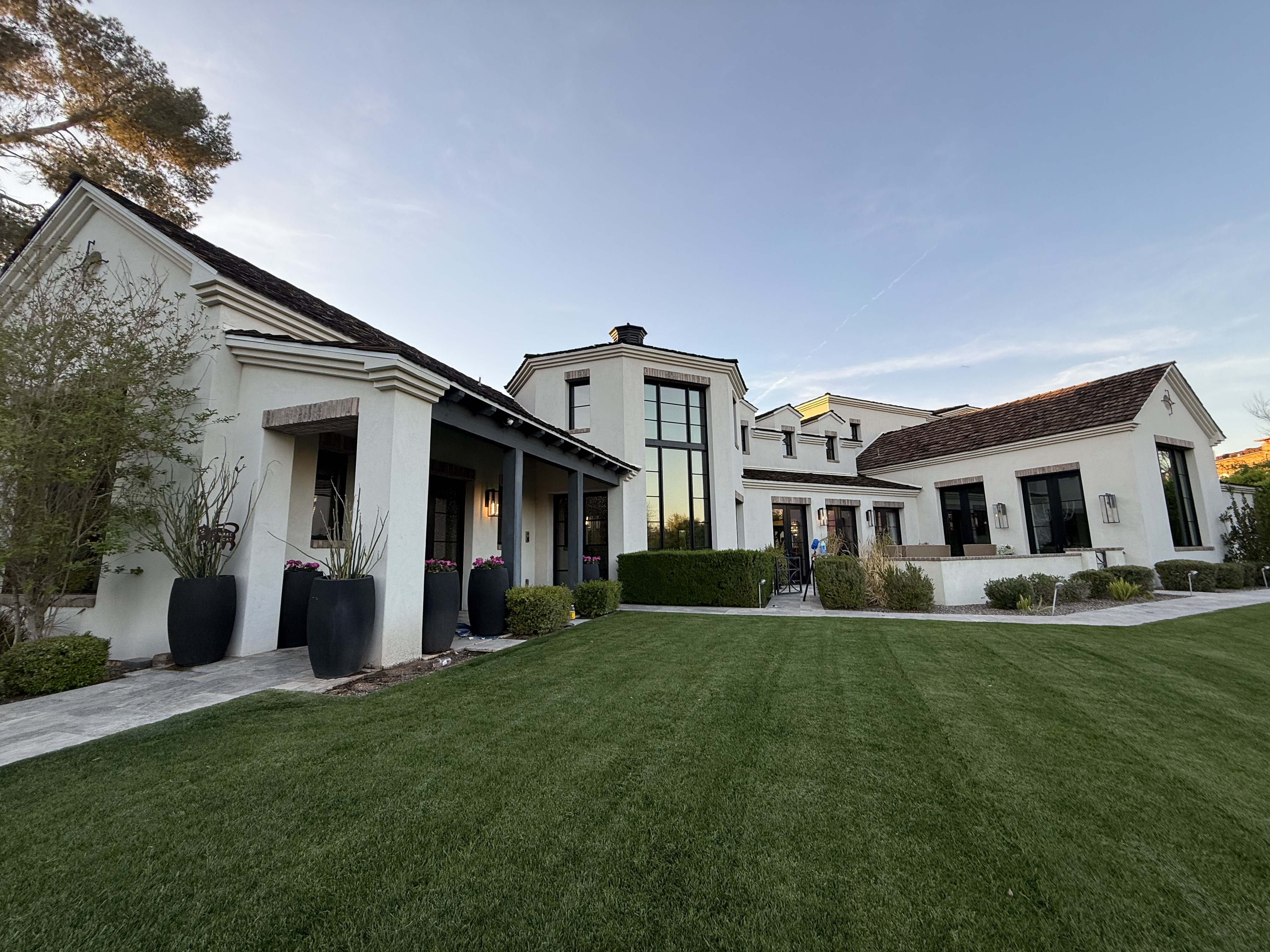 Luxury stucco home at dusk with impeccable lawn