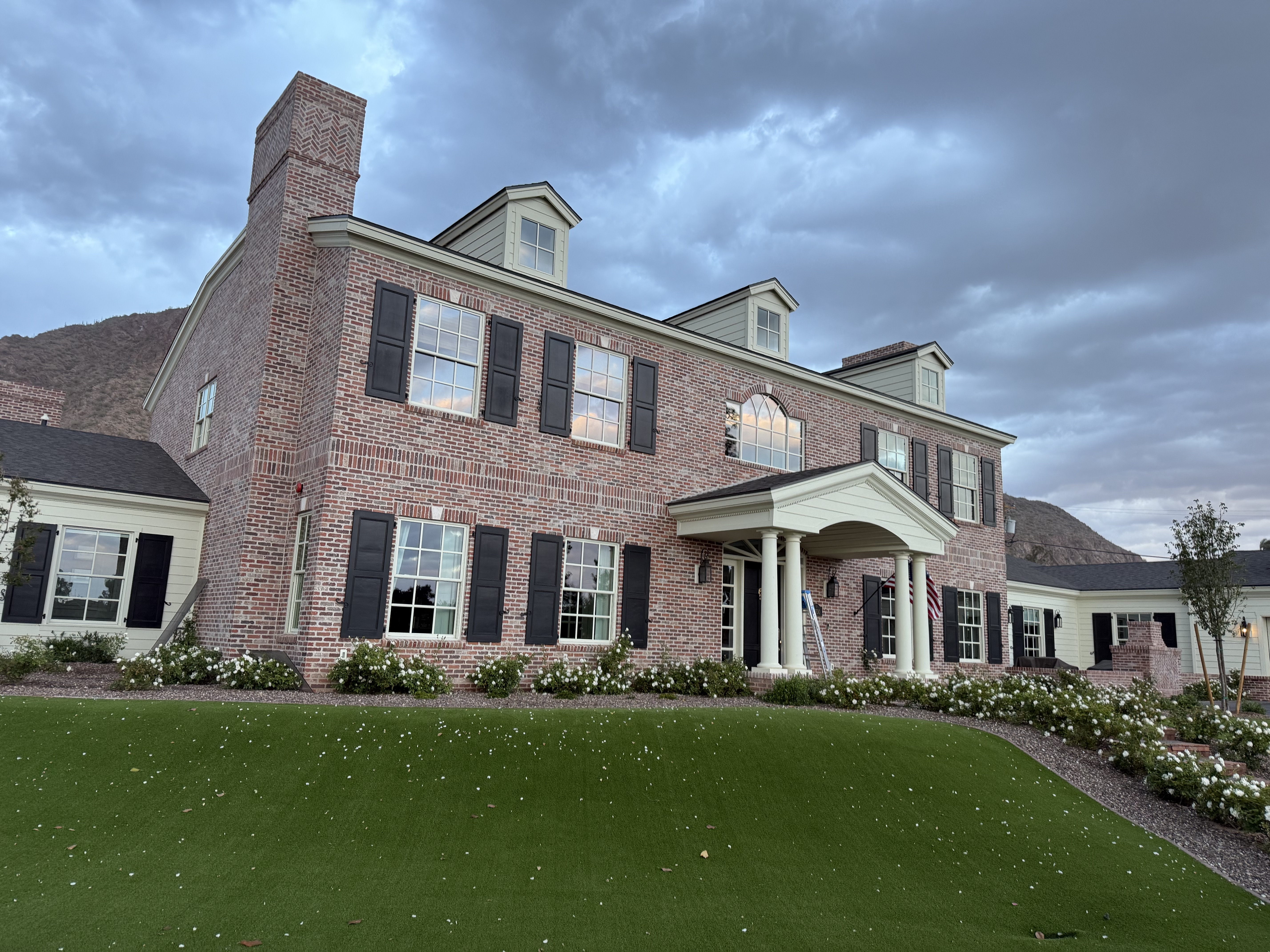 Colonial brick estate with mountain backdrop