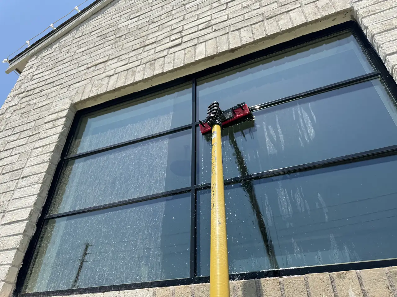 Water-fed brush in use on exterior glass